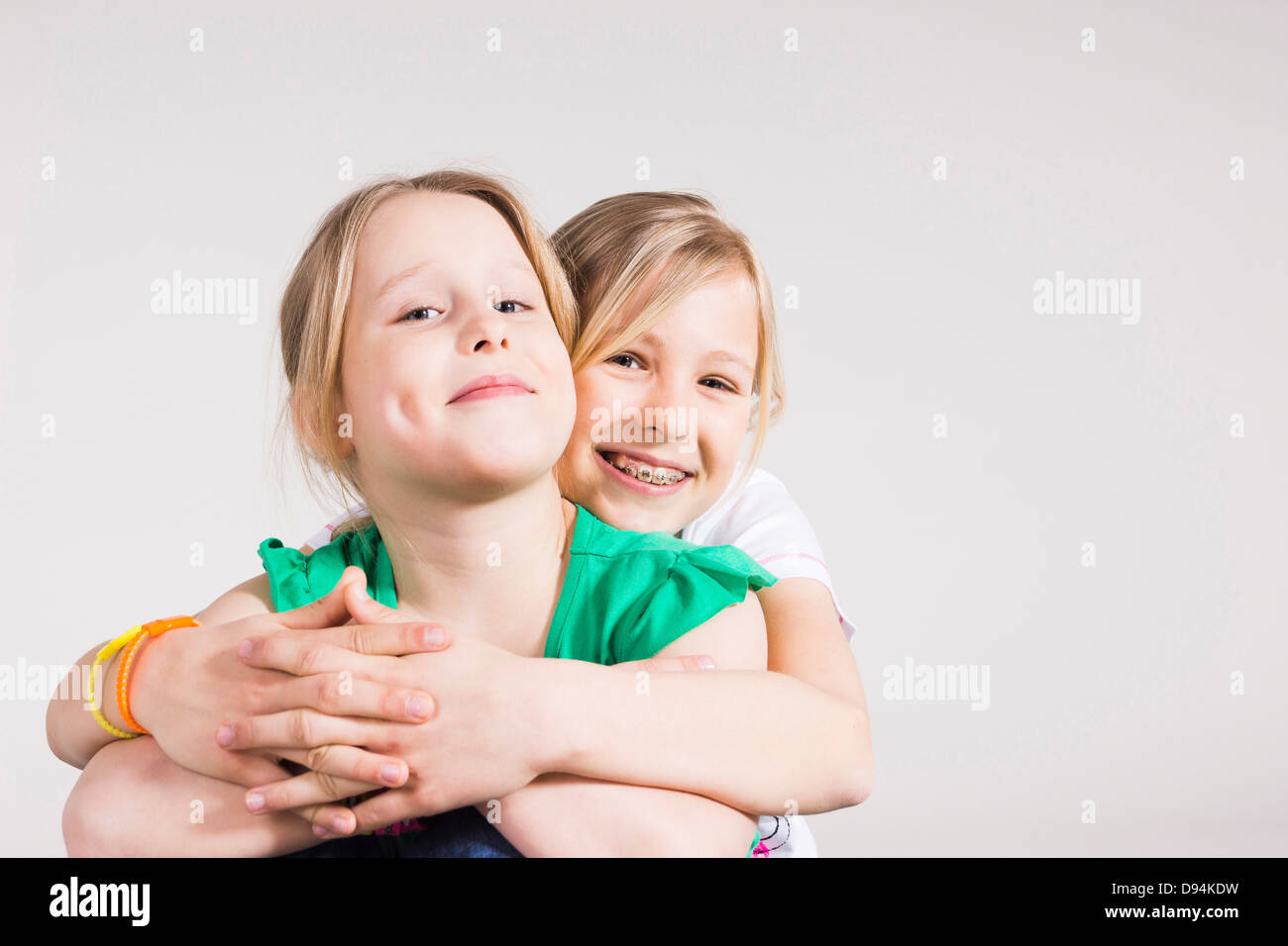 Portrait of Girl Hugging her Sister in Studio Stock Photo