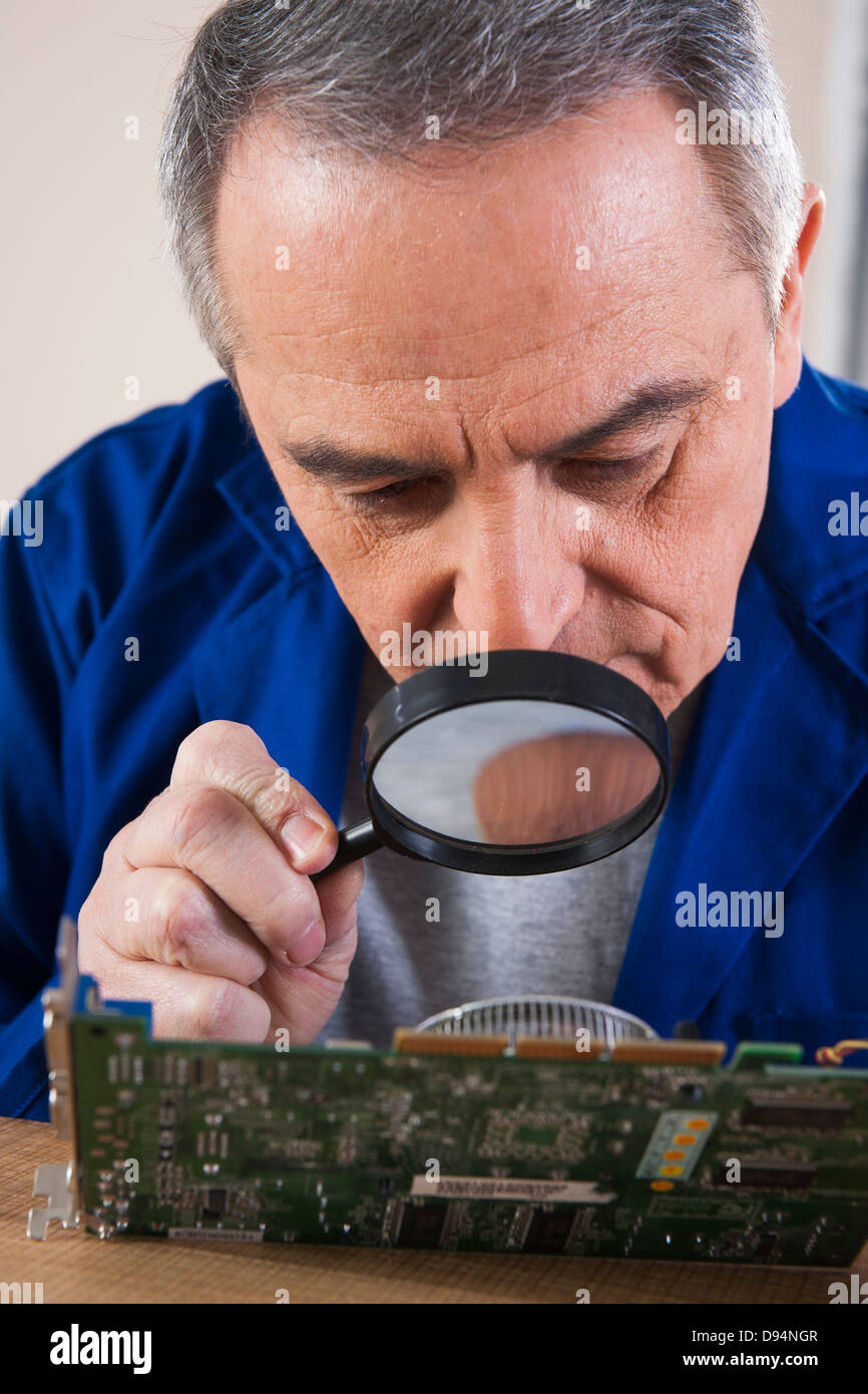 Man Looking at Circuit Board with Magnifying Glass in Studio Stock ...