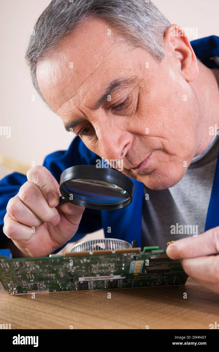 Man Looking at Circuit Board with Magnifying Glass in Studio Stock ...