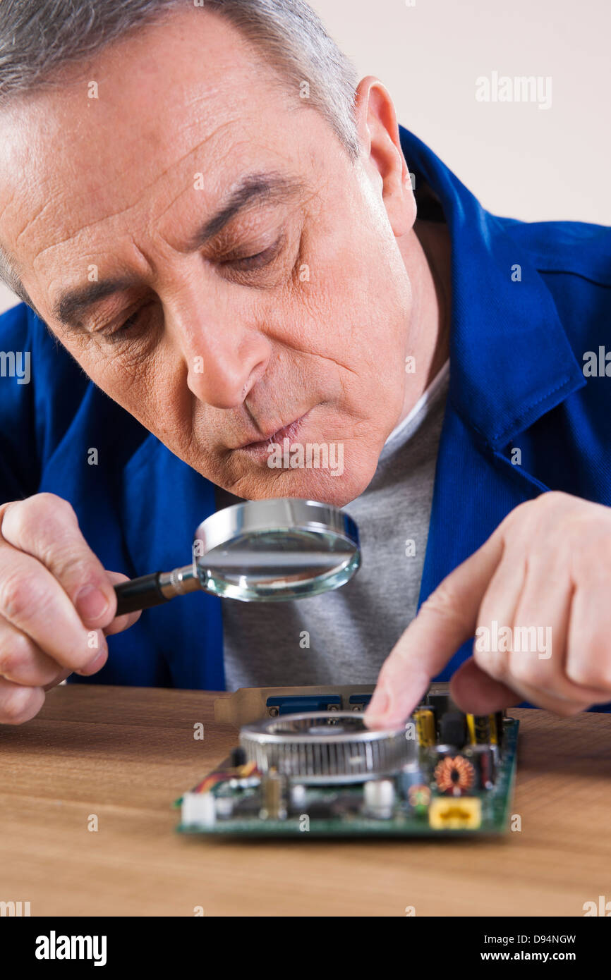 Man Looking at Circuit Board with Magnifying Glass in Studio Stock ...
