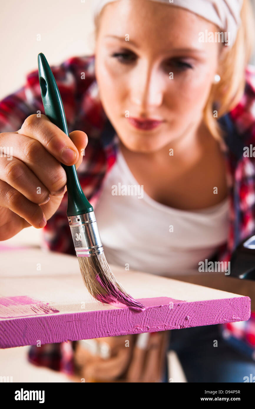 Studio Shot of Young Woman Painting Lumber Stock Photo
