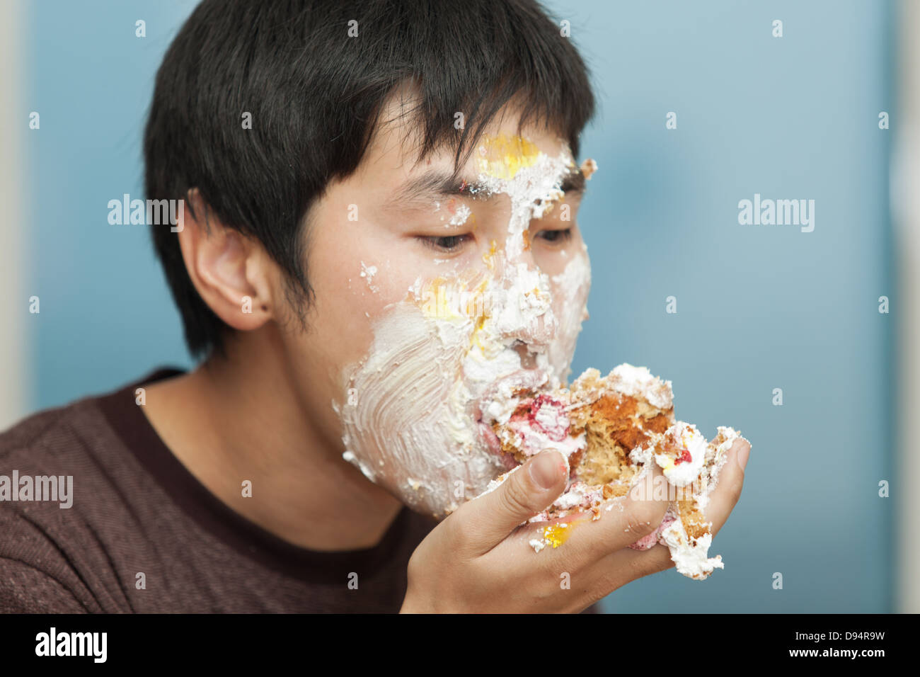 Men eating a piece of cake smeared with cream Stock Photo