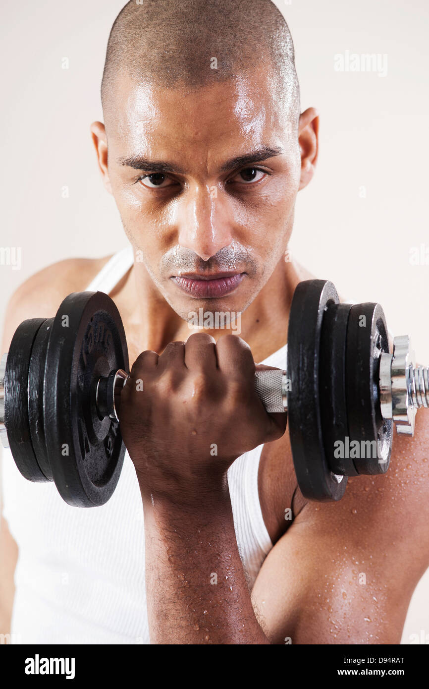 Man Wearing Work Out Clothes and Lifting Weights in Studio with White
