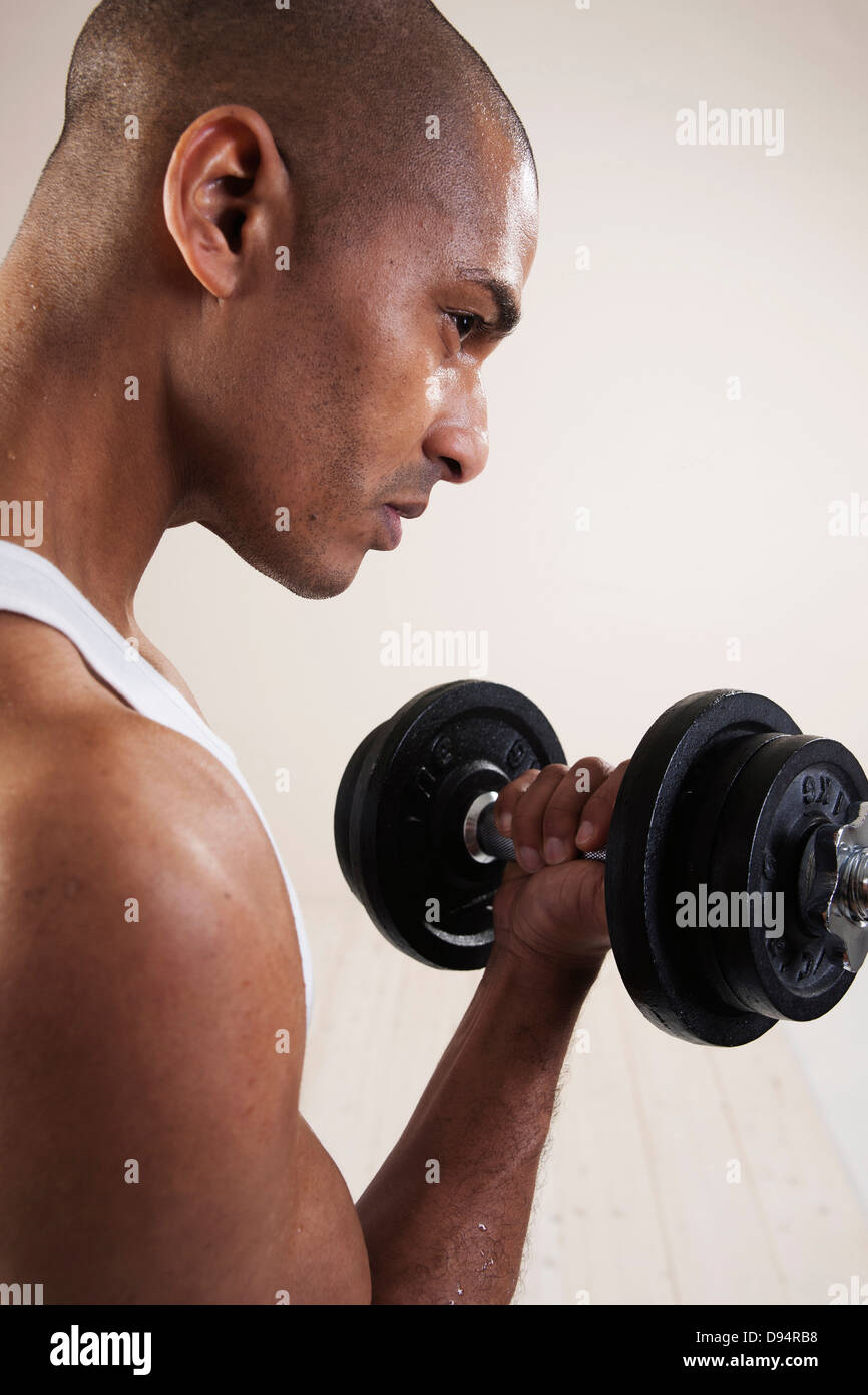 Man Wearing Work Out Clothes and Lifting Weights in Studio with White