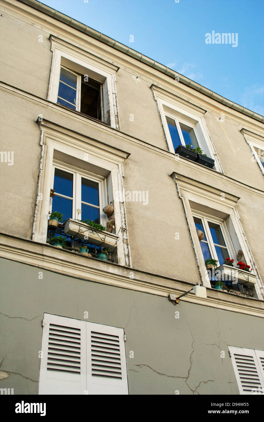 Apartments, windows, shutters and window boxes in Paris with a blue sky