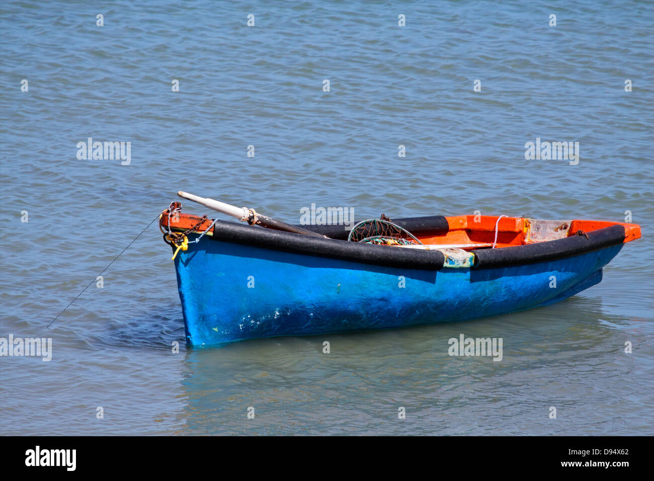 Anchored wooden fishing boat with reflection in water Stock Photo