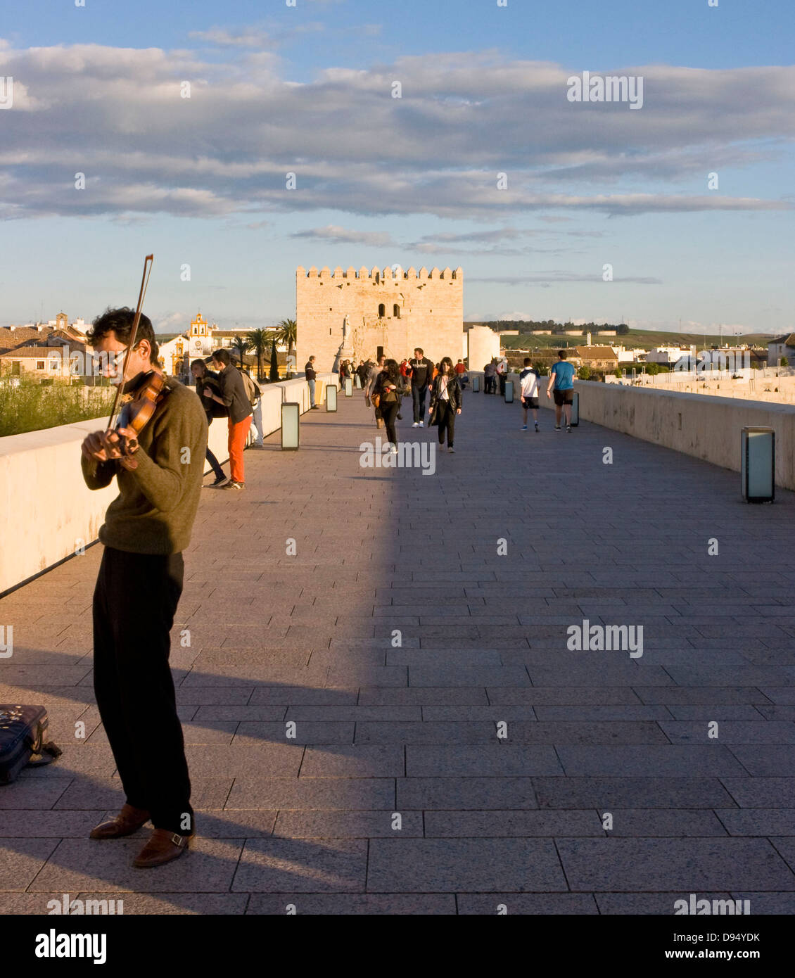 Violin playing busker on the Roman bridge (Puente Romano) at dusk Cordoba Andalusia Andalucia Spain Europe Stock Photo