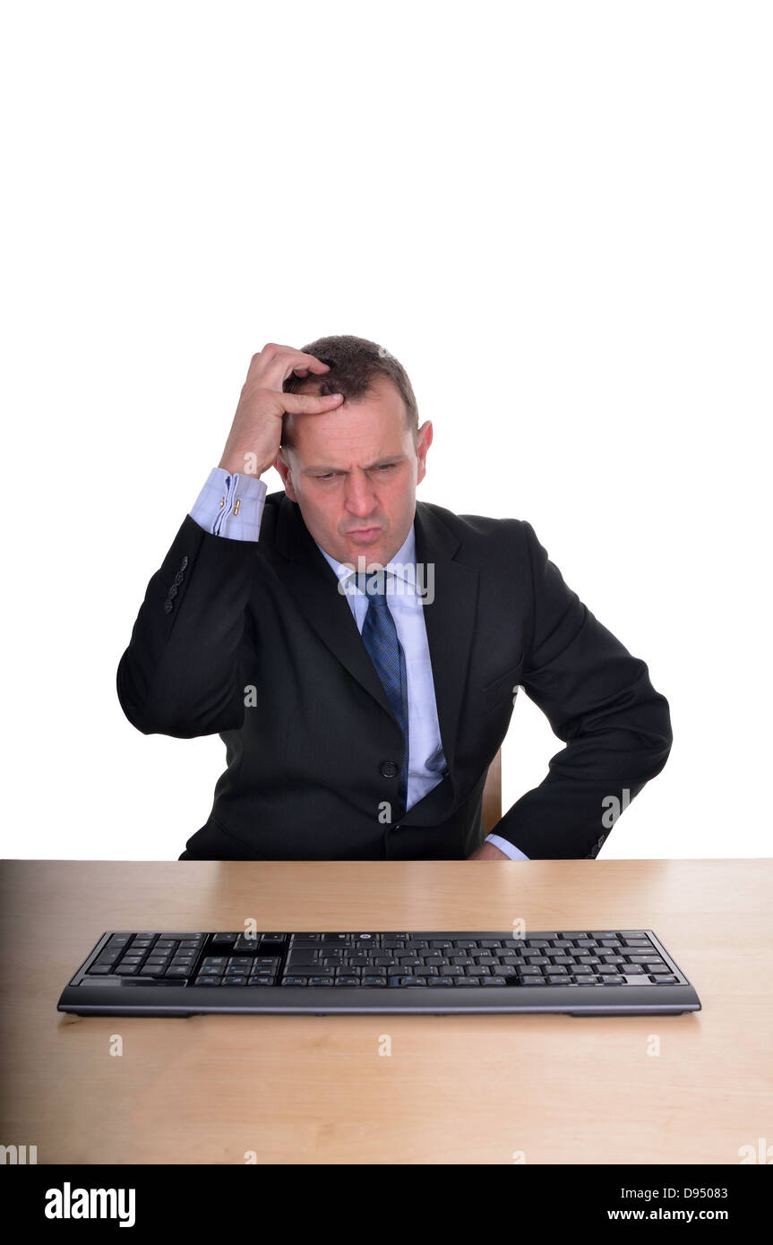 image of a businessman at a desk looking confused Stock Photo