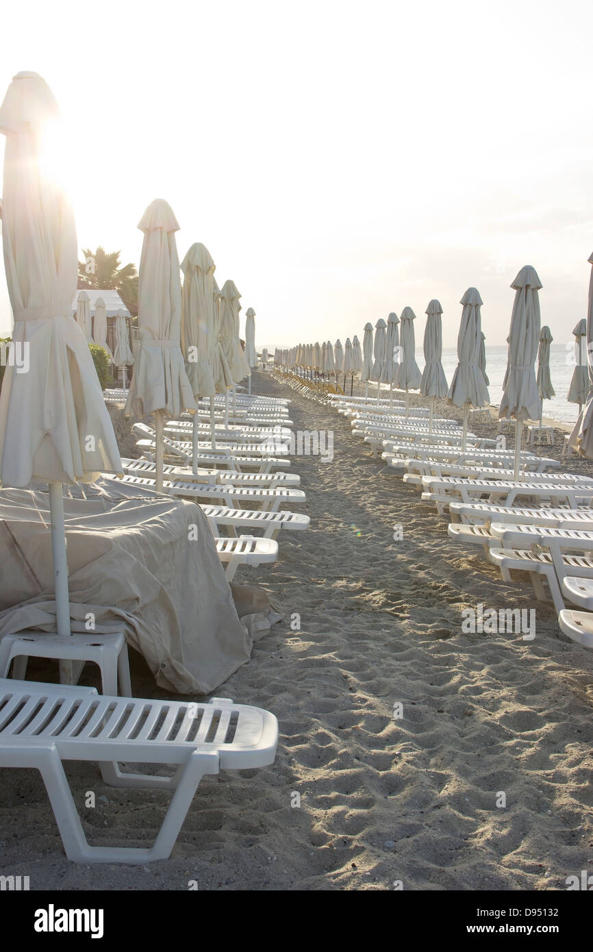Vacant mediterranean beach with umbrellas and deckchairs Stock Photo