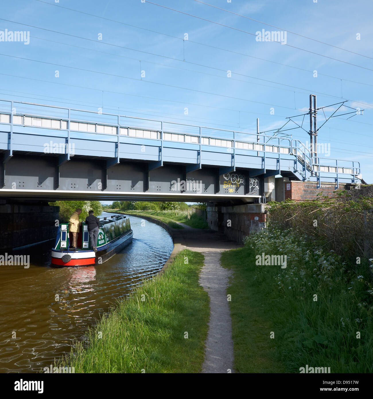 Narrow boat under railway bridge on the Trent and Mersey canal near Sandbach Cheshire UK Stock Photo