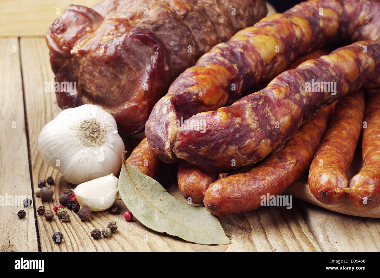 Different smoked sausage and meat on wooden table Stock Photo