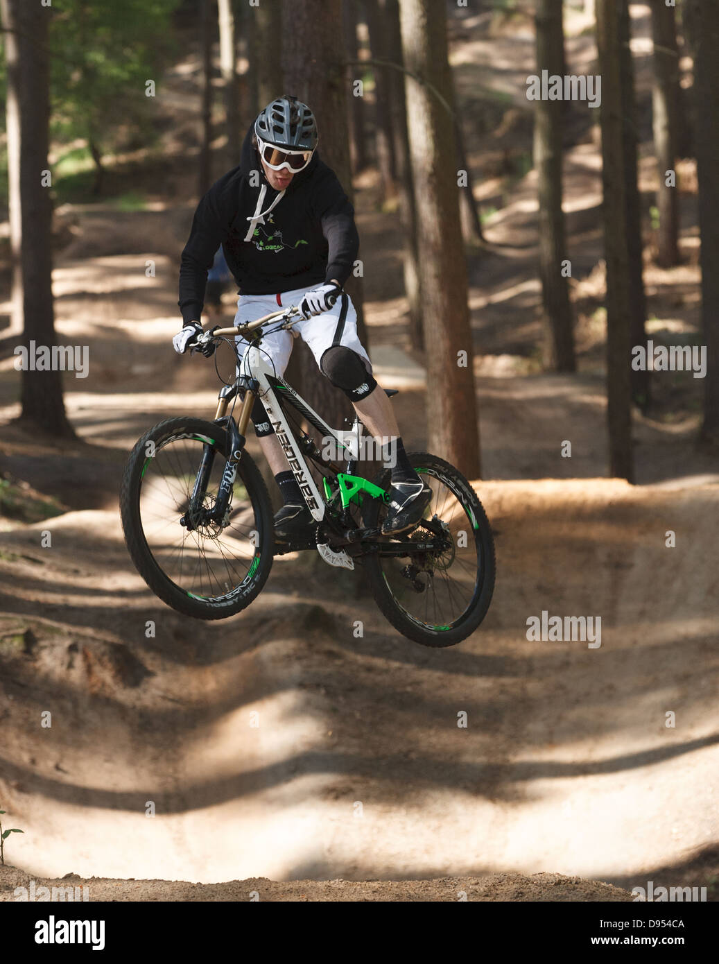 four cross cyclist mid jump mountain bike stunt Stock Photo - Alamy