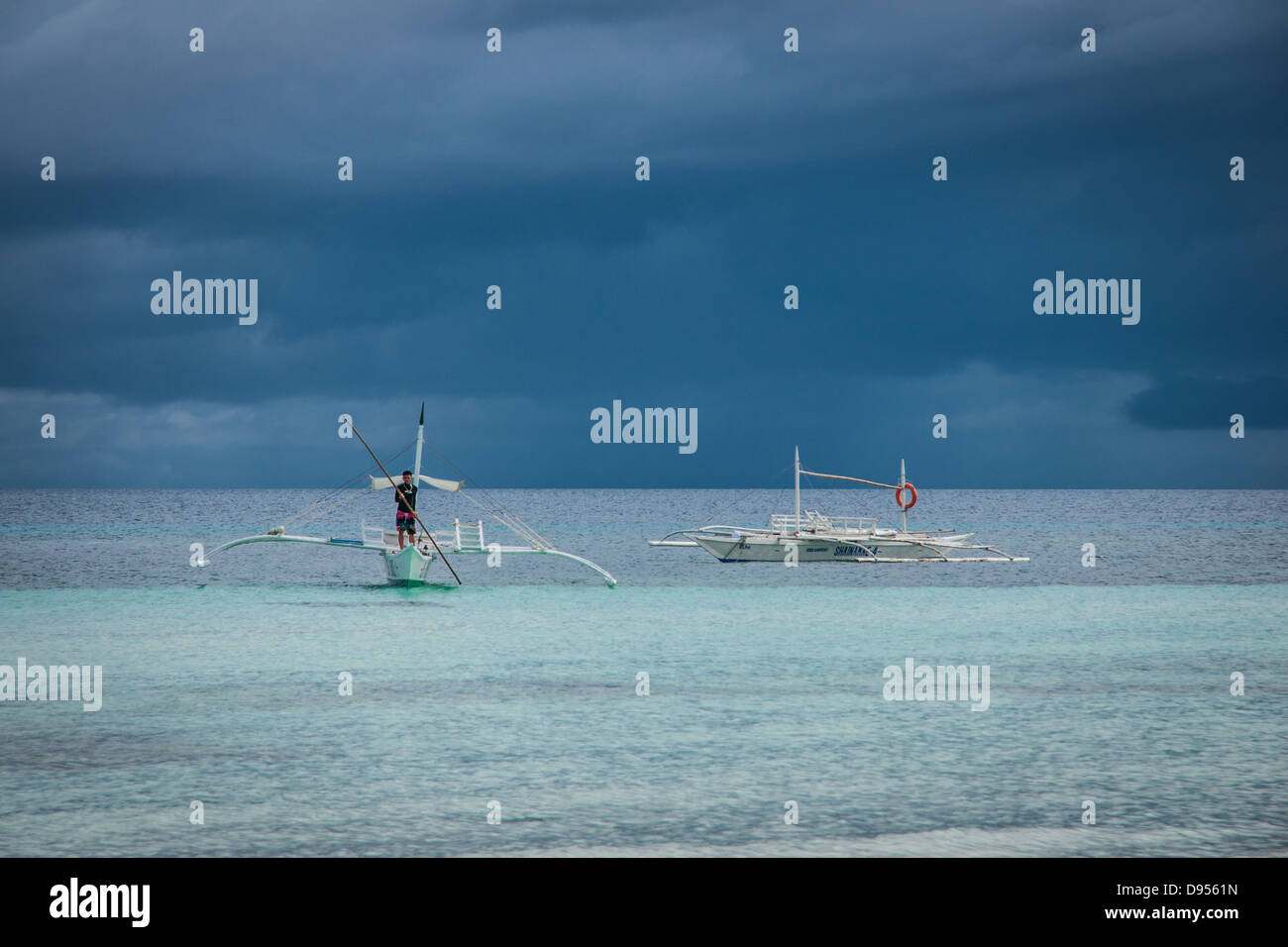 Outrigger bangka - a traditional Filipino fishing boat  with outriggers - coming in Dumaluan Beach, Panglao Island, Philippines Stock Photo
