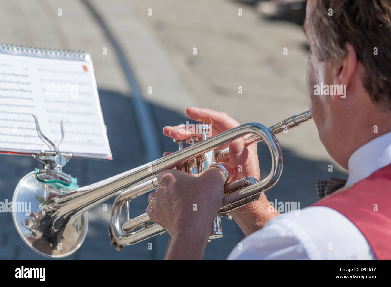 looking over shoulder of man playing trumpet with music sheet Stock Photo