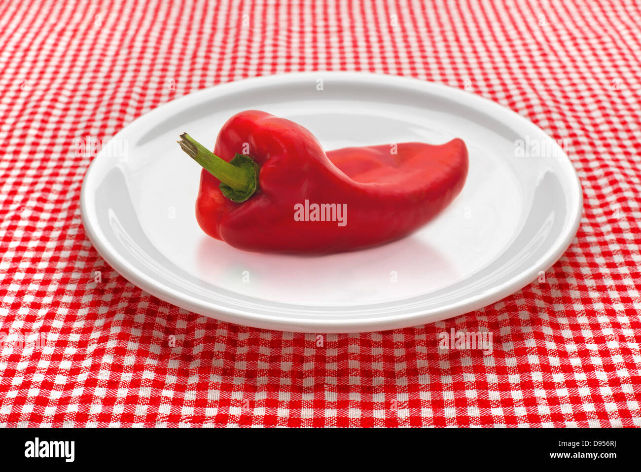 red pepper or paprika on white plate served on kitchen table. Stock Photo