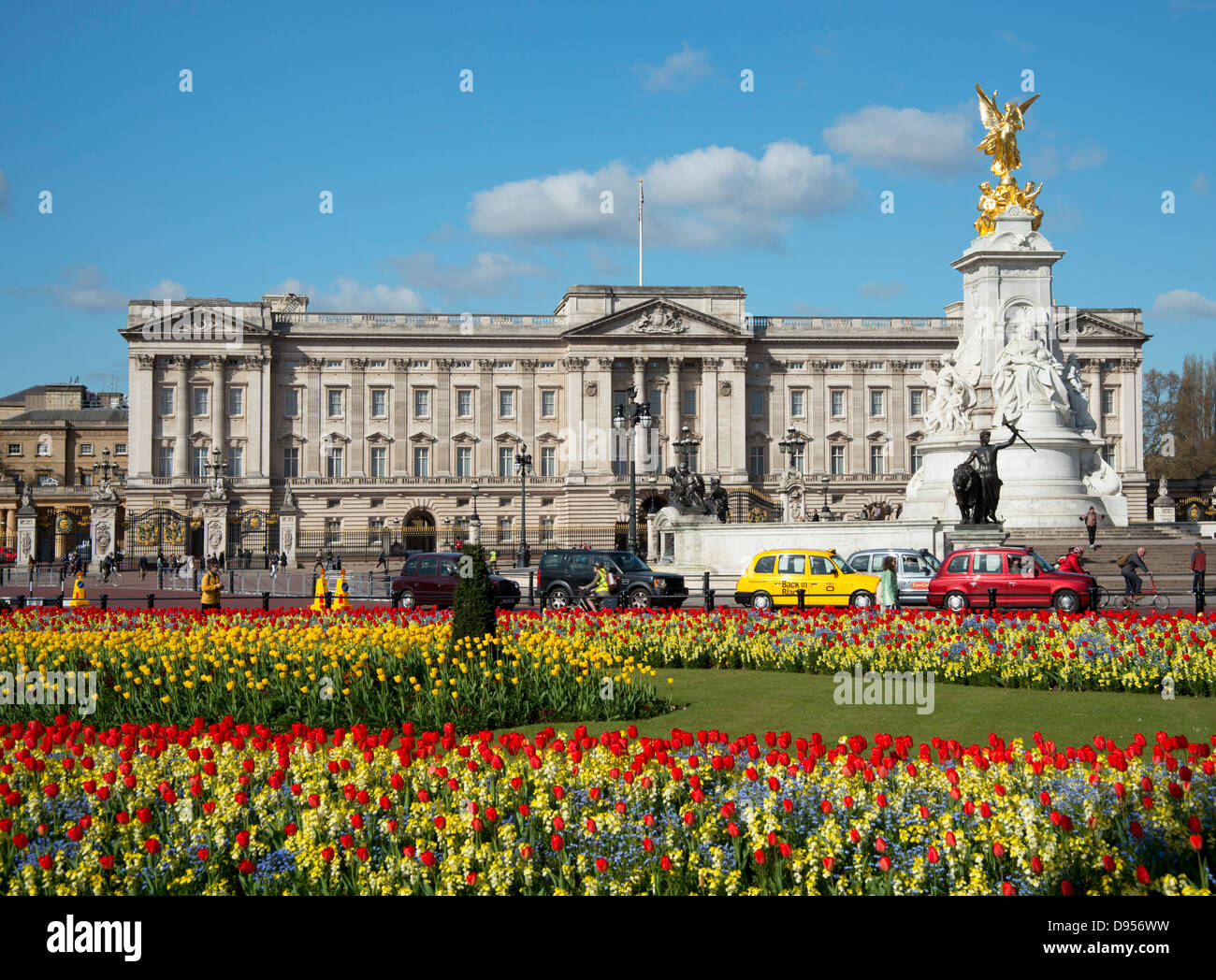 Red and yellow tulips and taxis in front of Buckingham Palace in April. London, UK Stock Photo