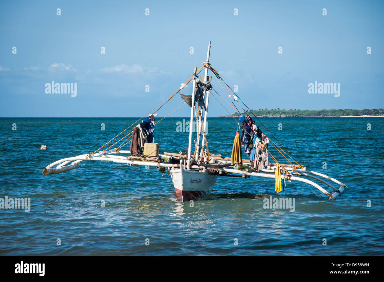 Drying clothes on traditional Filipino fishing boat with outriggers at Baigad Beach, Santa Fe, Bantayan, Philippines Stock Photo