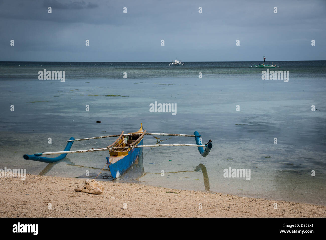 Bangka or traditional Filipino fishing boat with outriggers moored at San Juan, Siquijor, Cebu, Central Visayas, Philippines Stock Photo