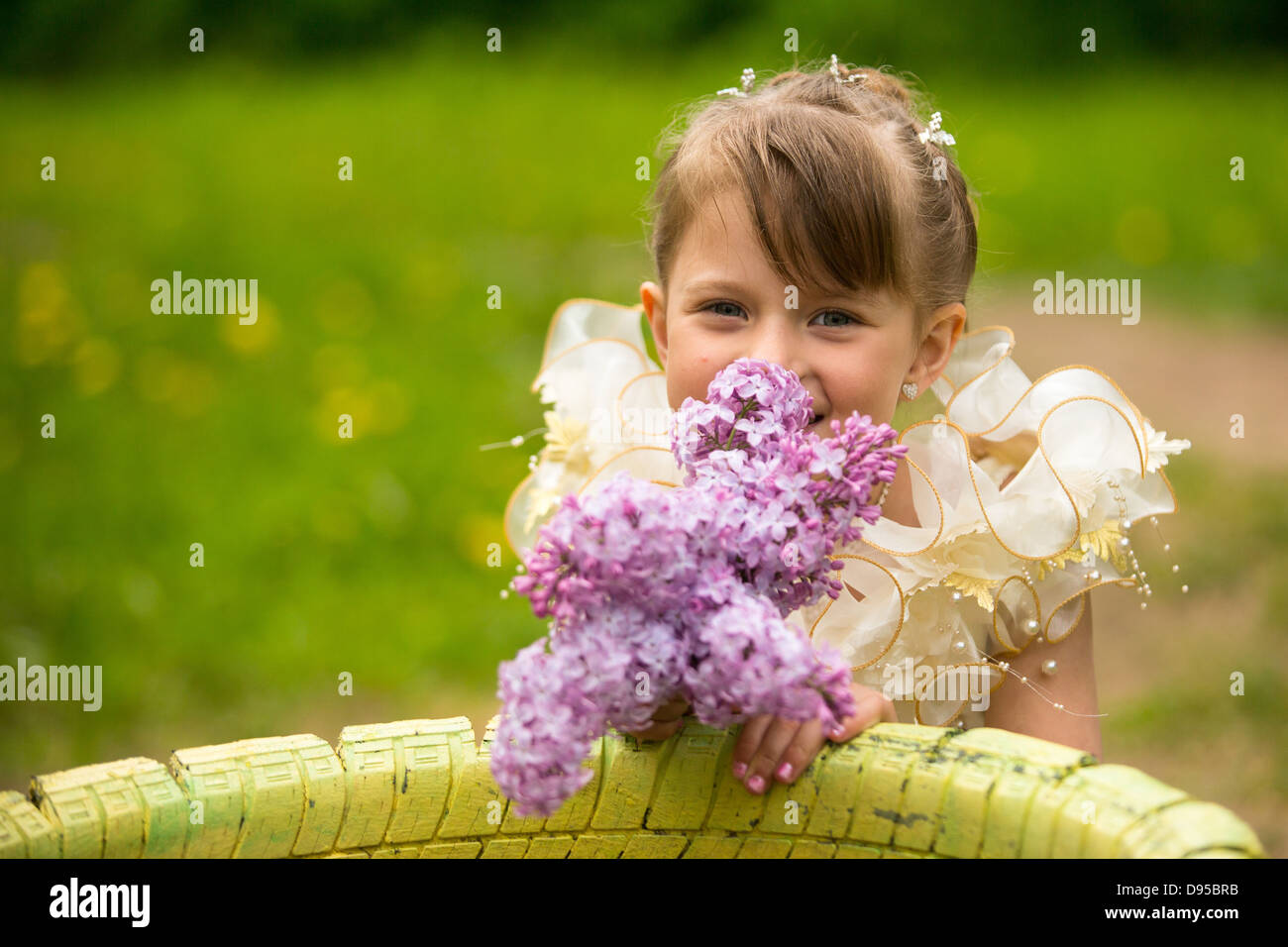Little lovely girl with a bouquet of lilacs outdoors Stock Photo - Alamy