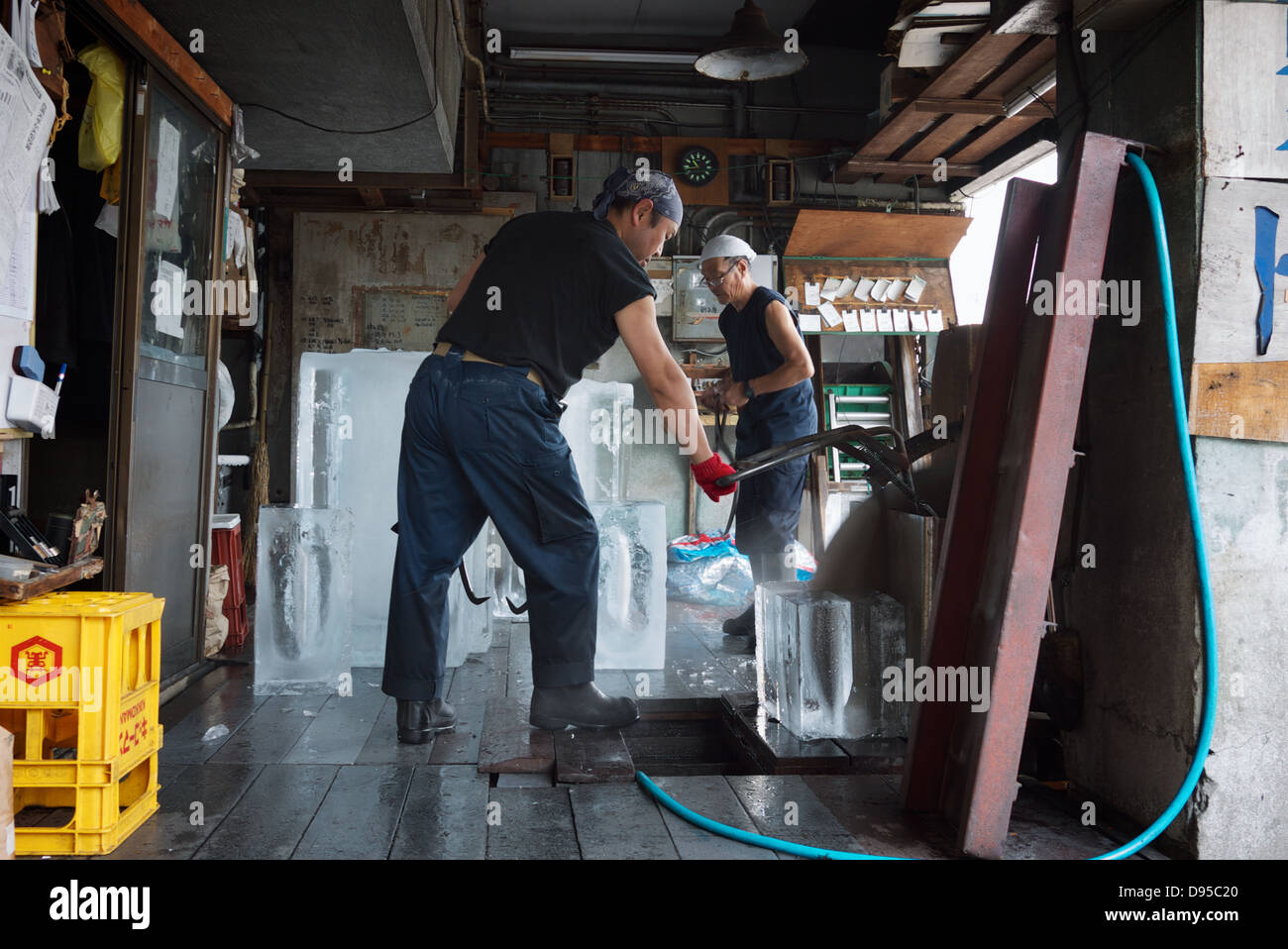 Two Japanese male workers preparing blocks of ice for fish stores at