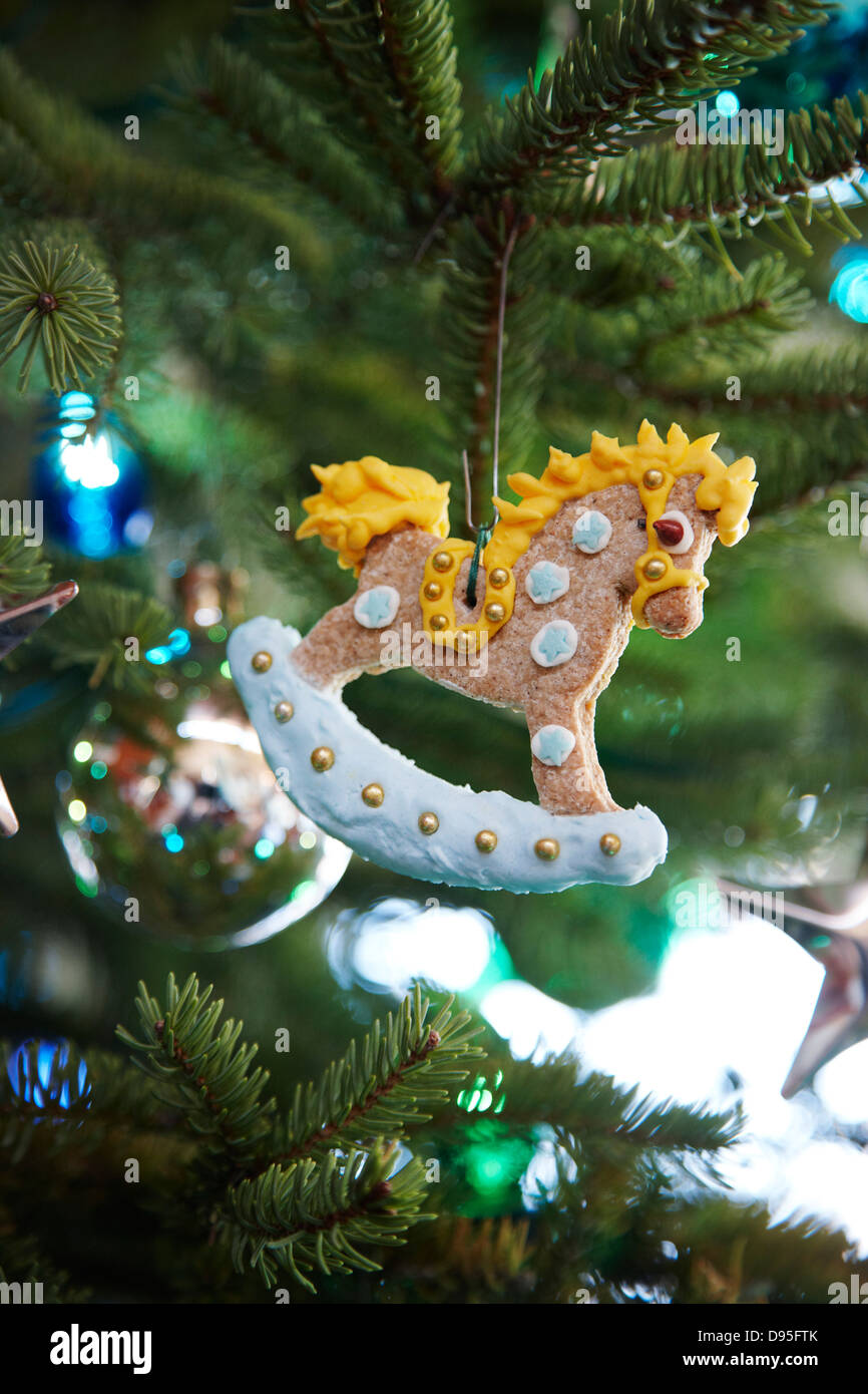 gingerbread rocking horse decorated with icing hanging on a pine tree as a Christmas ornament decoration, Canada Stock Photo