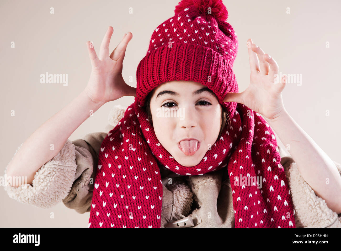 Portrait of Girl making faces wearing Hat and Scarf in Studio Stock Photo