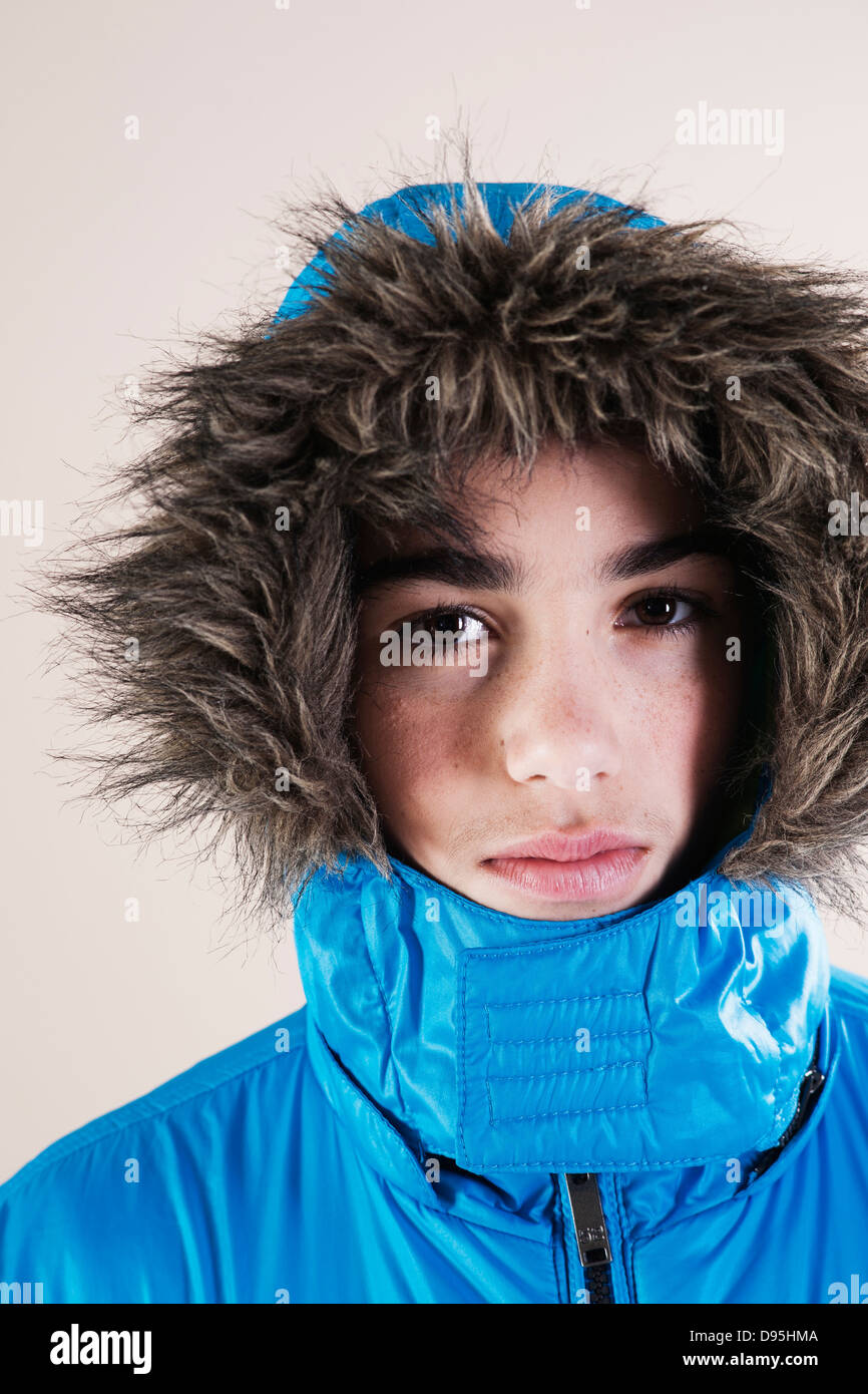 Portrait of Boy in Winter Jacket with Faux Fur Trimmed Hood in Studio Stock Photo