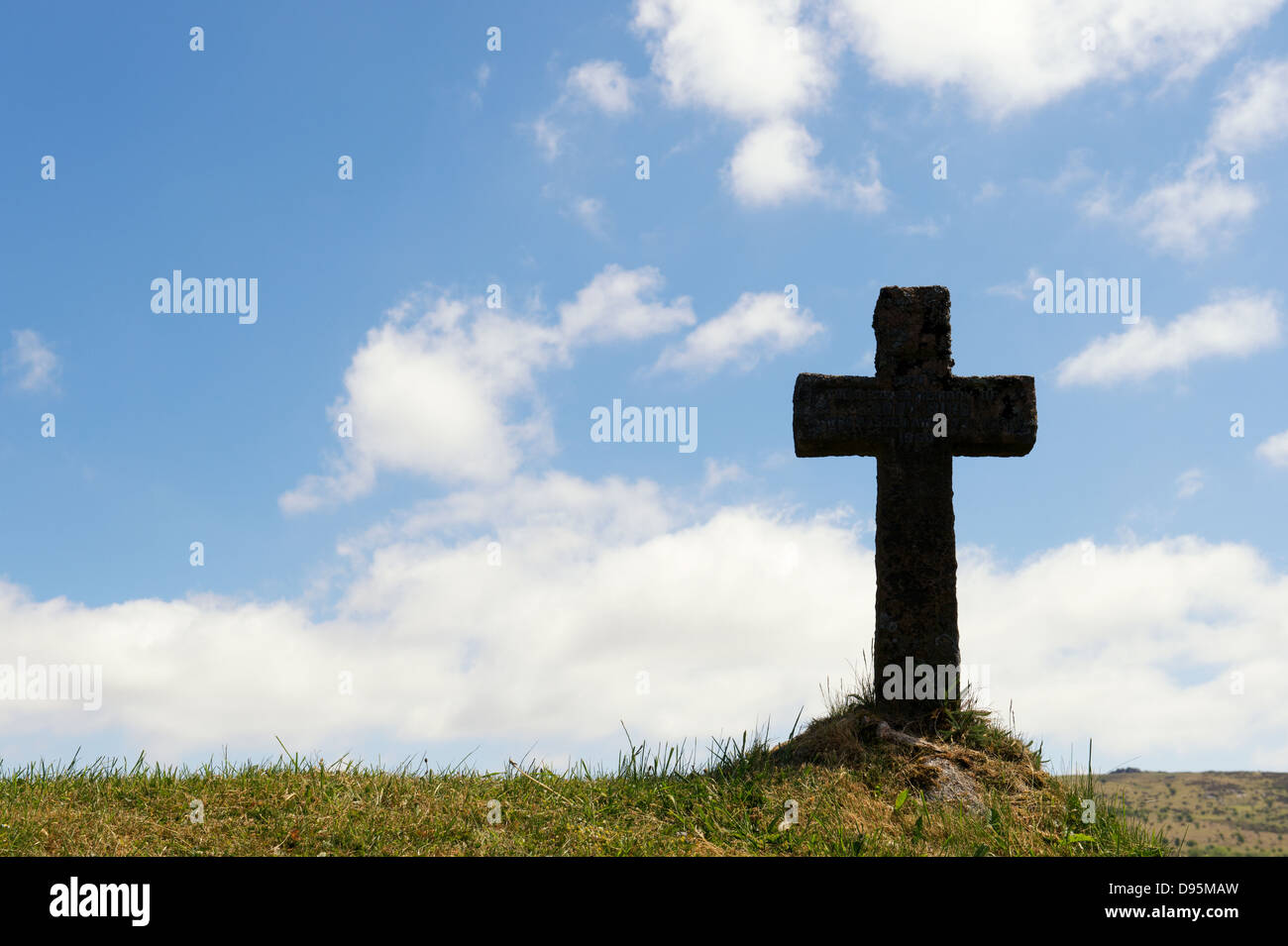 Gravestone cross on a bank of grass. Silhouette. St Pancras Church. Widecombe in the Moor. Dartmoor, Devon, England Stock Photo