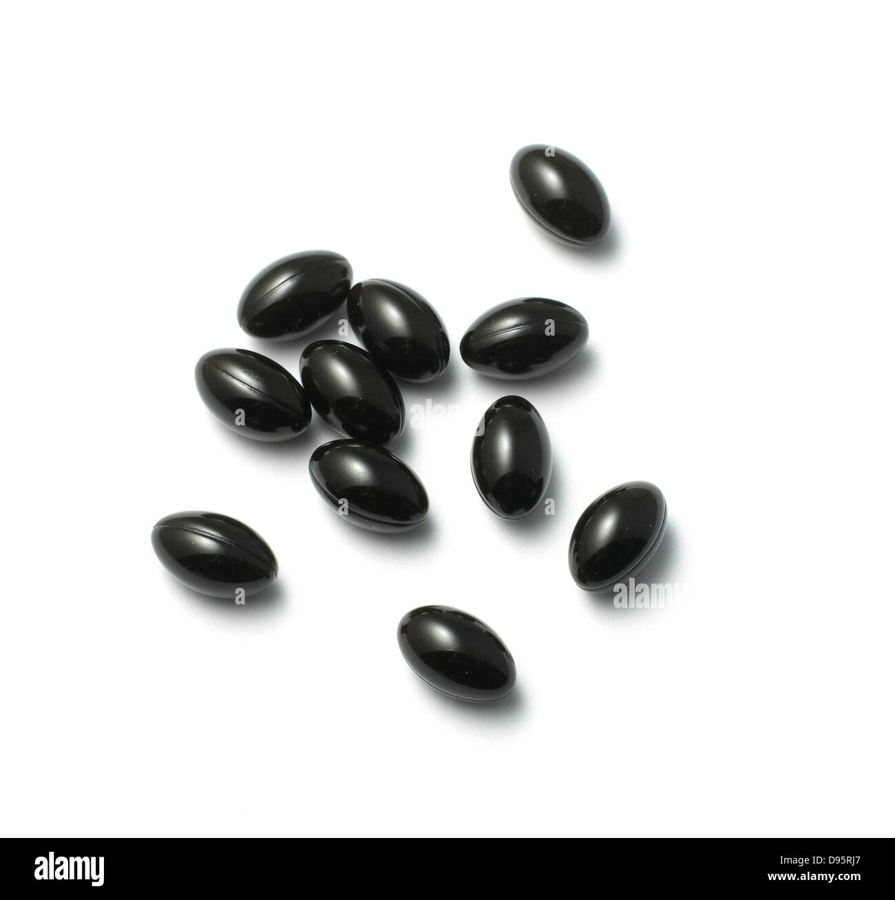 black pills cut out onto a white background Stock Photo
