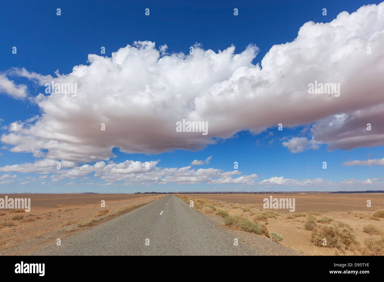 Road in the Sahara desert with cloudy blue sky Stock Photo - Alamy