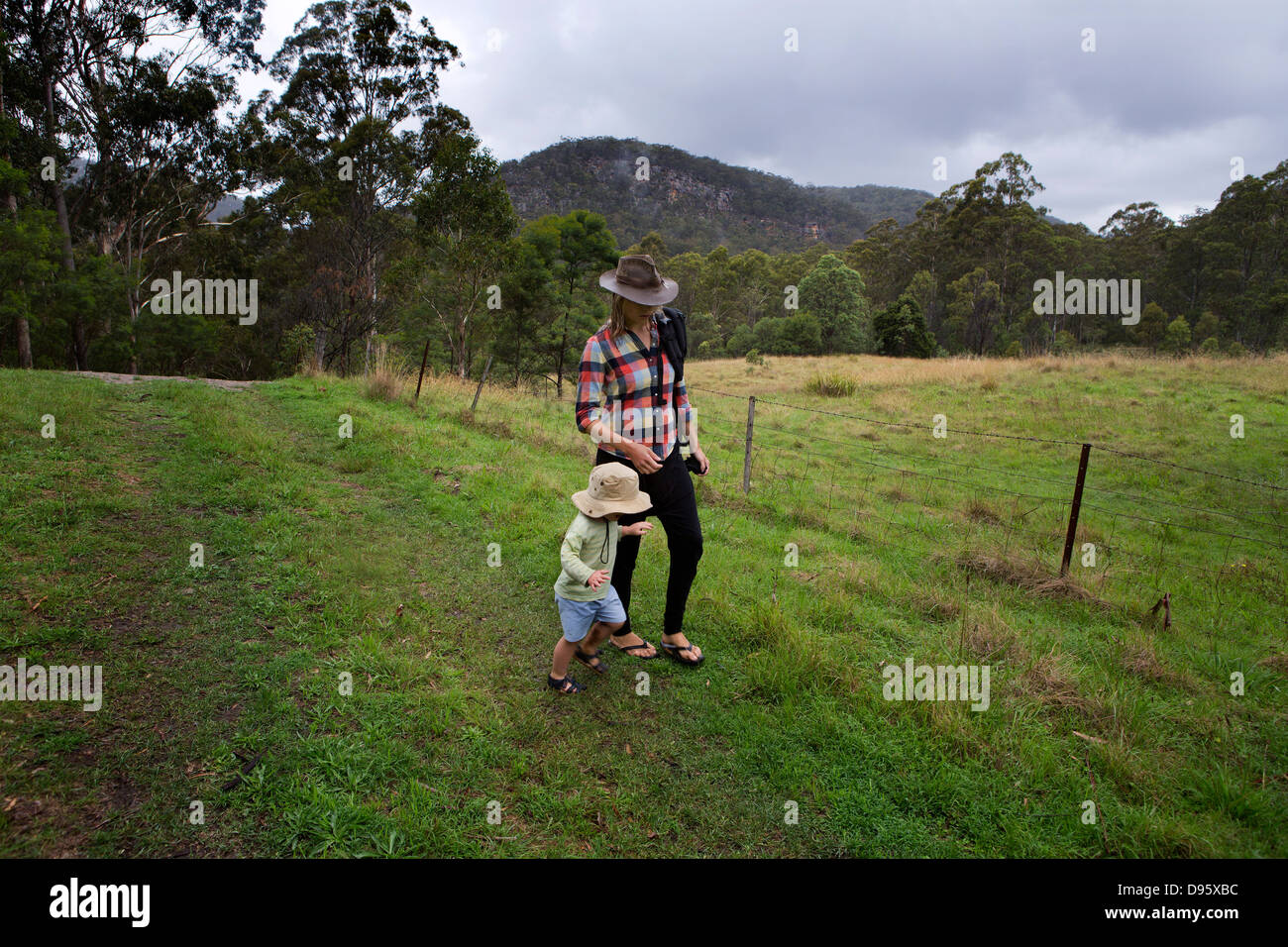 Mother with check shirt walks with her 3 year old son through fields Stock Photo