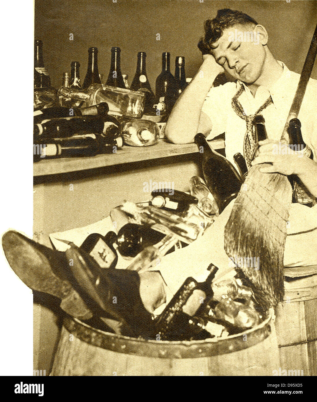 Repeal of  Prohibition, 1933. American barman exhausted by clearing up the empty bottles after the celebration of the laws prohibiting the sale of alcohol. Stock Photo