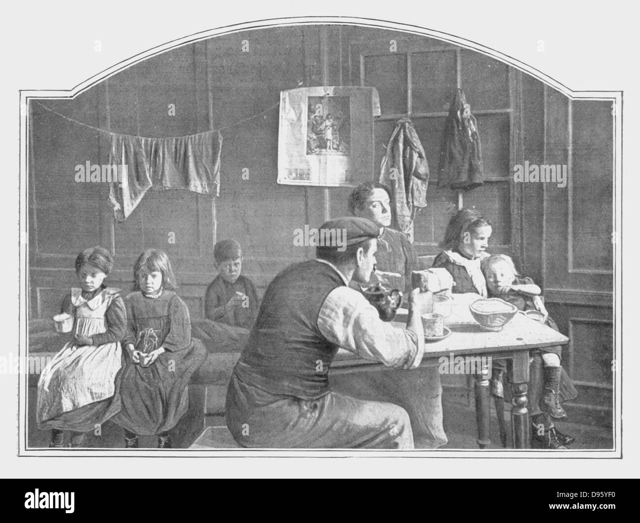Typical scene in an early twentieth century London slum with parents and five children living in a single room. Stock Photo