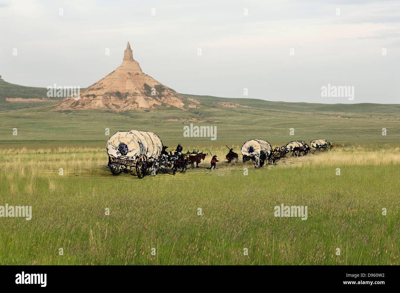 Covered wagons passing Chimney Rock, a landmark on the Oregon Trail, Nebraska. Hand-colored woodcut combined with a photograph Stock Photo