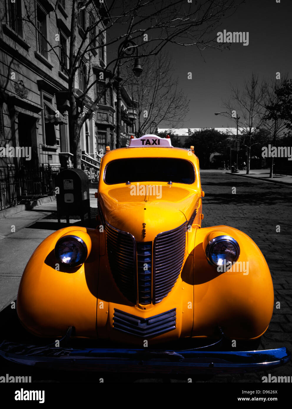 Face on view of vintage Yellow Cab co. car parked outside faux period buildings at Universal Studios theme park, Florida, USA. Selective colour. Stock Photo