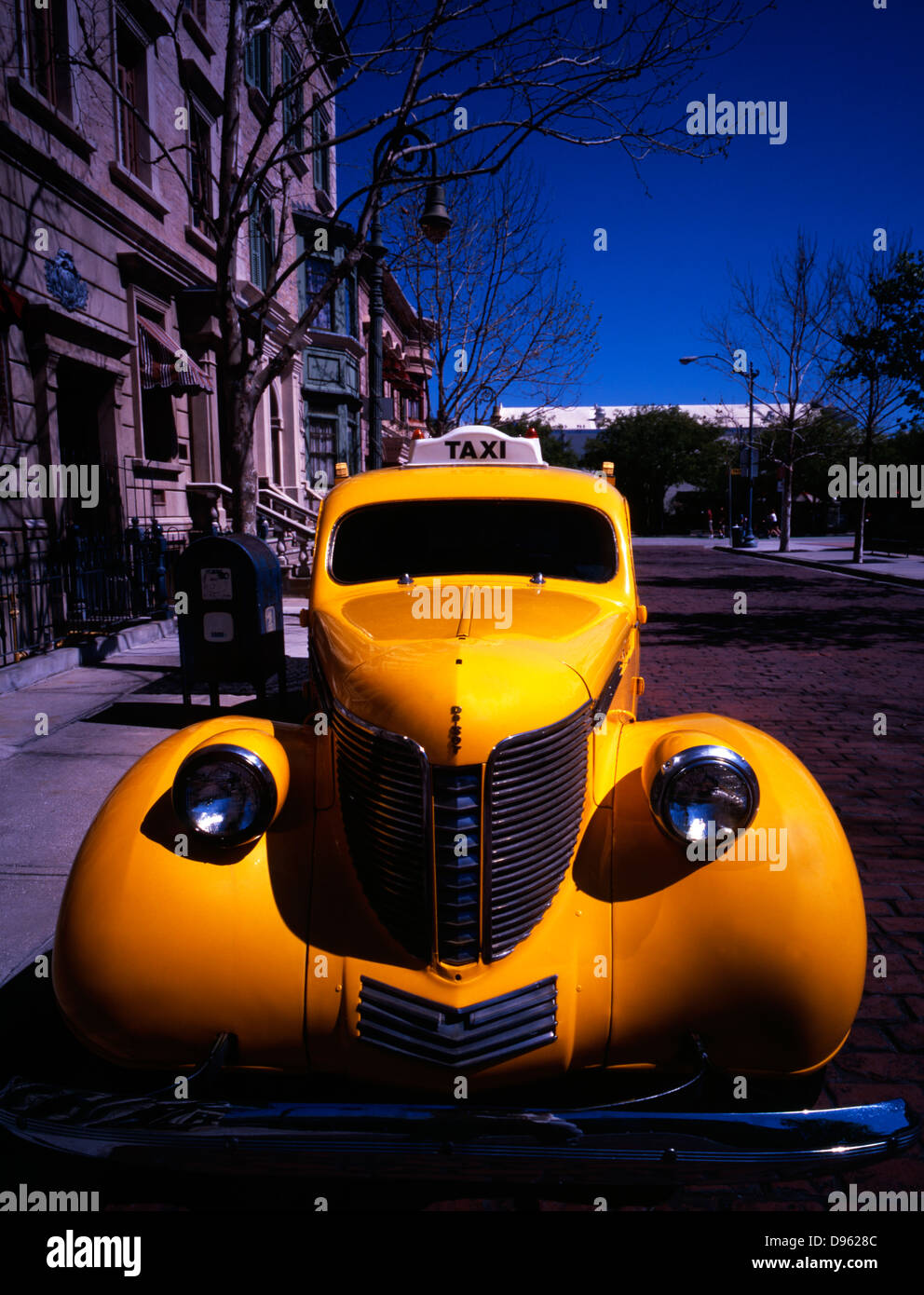 Face on view of vintage Yellow Cab co. car parked outside faux period buildings at Universal Studios theme park, Florida, USA. Stock Photo