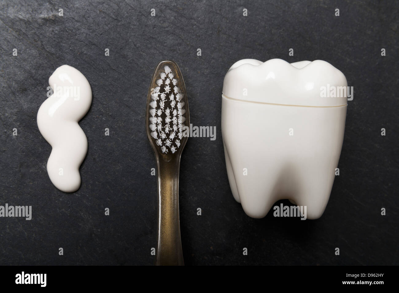Tooth shaped plastic container, tooth brush and paste on slate board