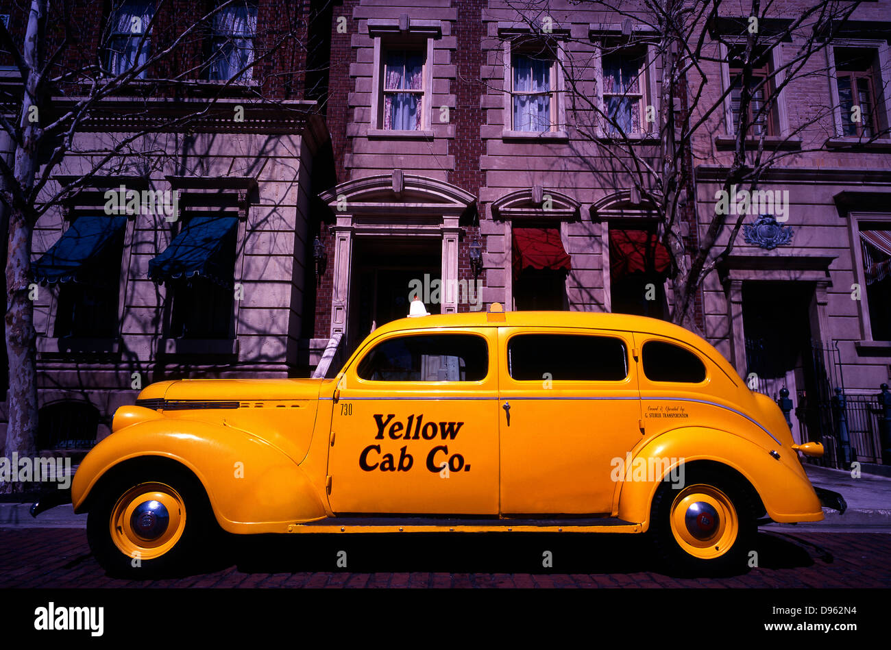 Side view of vintage Yellow Cab co. car parked outside faux period buildings at Universal Studios theme park, Florida, USA. Stock Photo