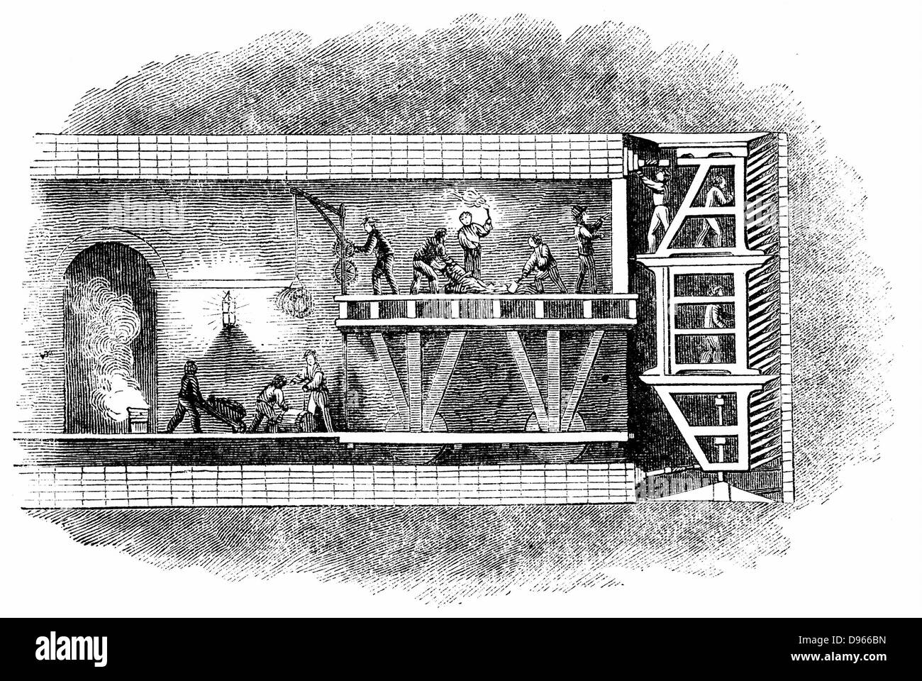 Section of Thames Tunnel (1825-1843) showing men at work in shield (right) while others take away spoil. Picture also shows construction of arched masonry lining using Roman cement behind shield. Patent for this first tunnelling shield taken out by Marc Isambart Brunel 1818. Isambard Kingdom Brunel was site engineer. Tunnel still used by electric trains between Whitechapel and New Cross, London. Woodcut 1842. Stock Photo