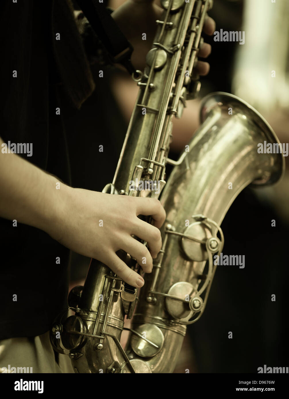 jazz band playing on the street, selective focus on the hands with sax Stock Photo