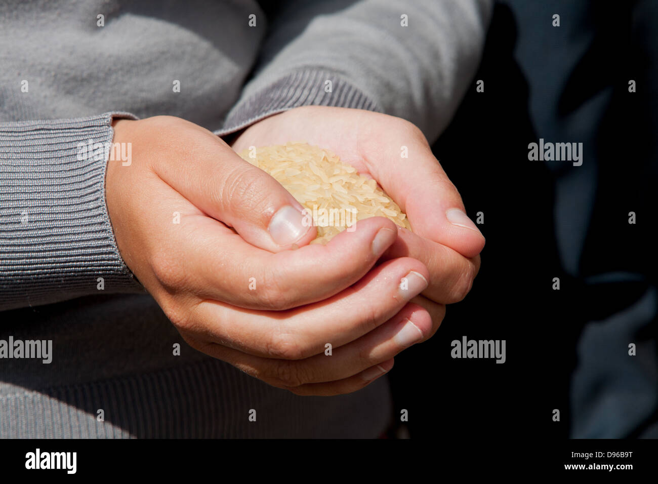 hands holding a portion of rice, to throw at the bride and groom at the