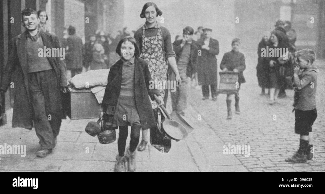 Women and children made homeless by German bombing, walking through  a Liverpool street after a nightime raid March 1941. World War II Stock Photo