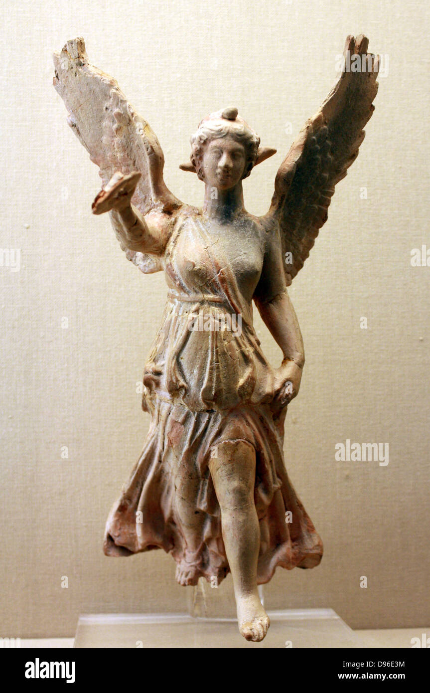 Nike (goddess of Victory) about to land. This terracotta figure of Nike  holds out a wreath for a victor, Her garment clings to her body, revealing  the contours beneath but also billows