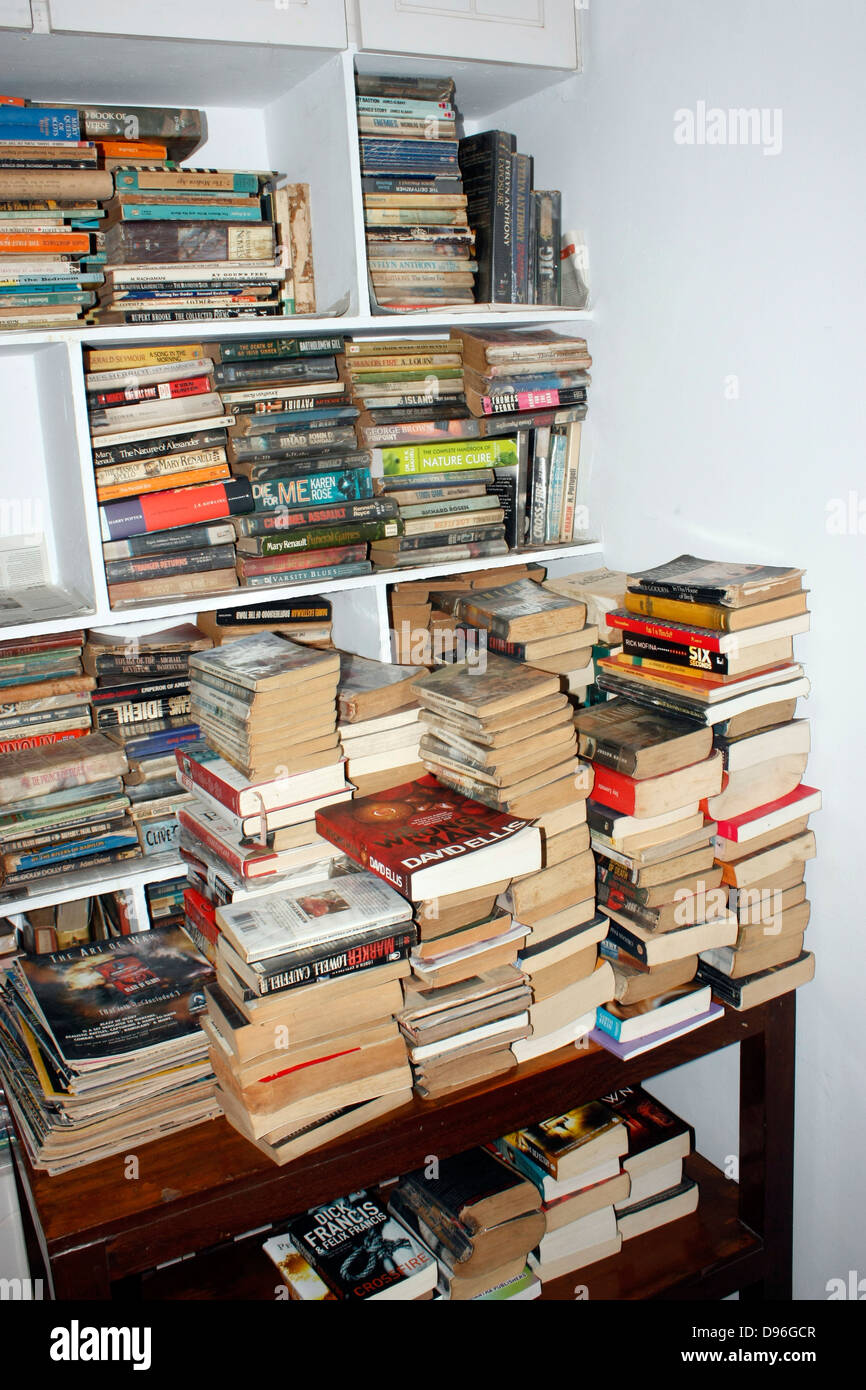 A pile of books stacked and arranged on a book rack in a shelf library Stock Photo