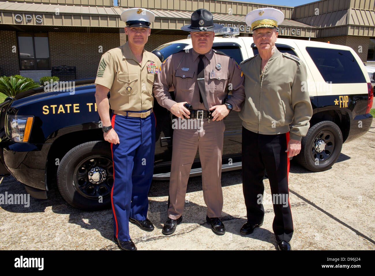 The 35th Commandant of the Marine Corps, Gen. James F. Amos, right, and 17th Sergeant Major of the Marine Corps, Sgt. Maj. Micheal P. Barrett, left, pose for a photo a Florida Highway Patrol officer after visiting the Marine Fighter Attack Training Squadr Stock Photo