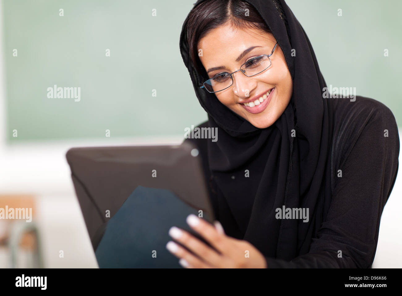 female Muslim college student using tablet computer in classroom Stock Photo
