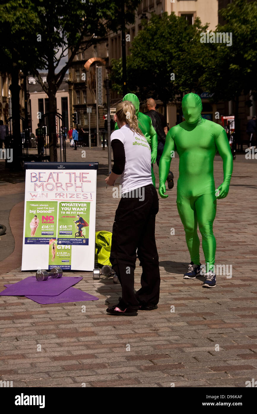 Beat The Morph and win prizes as two men wearing green morph outfits get ready to exercise in Dundee city centre,UK Stock Photo