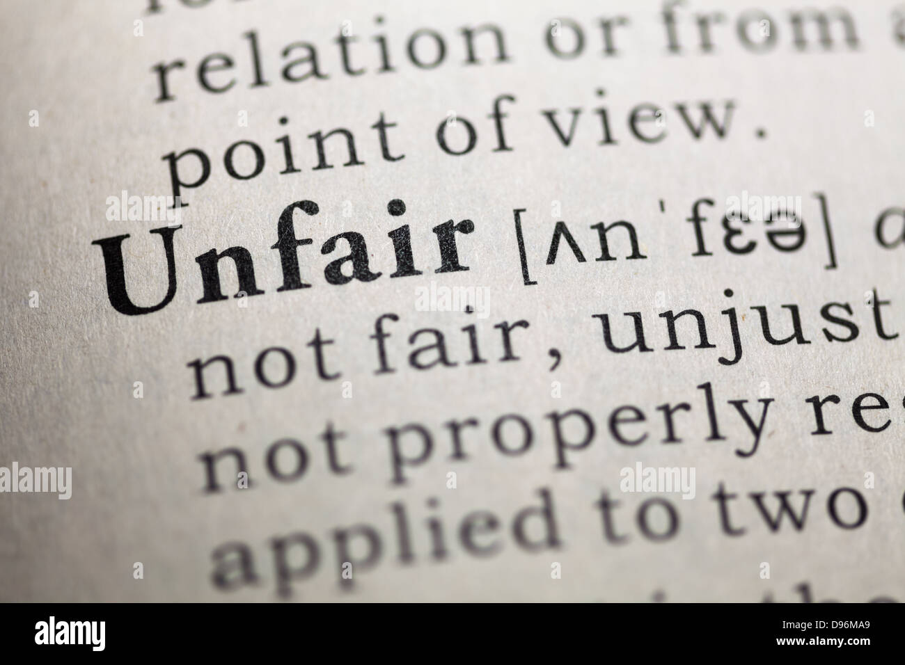 Dictionary definition of the word unfair. Stock Photo