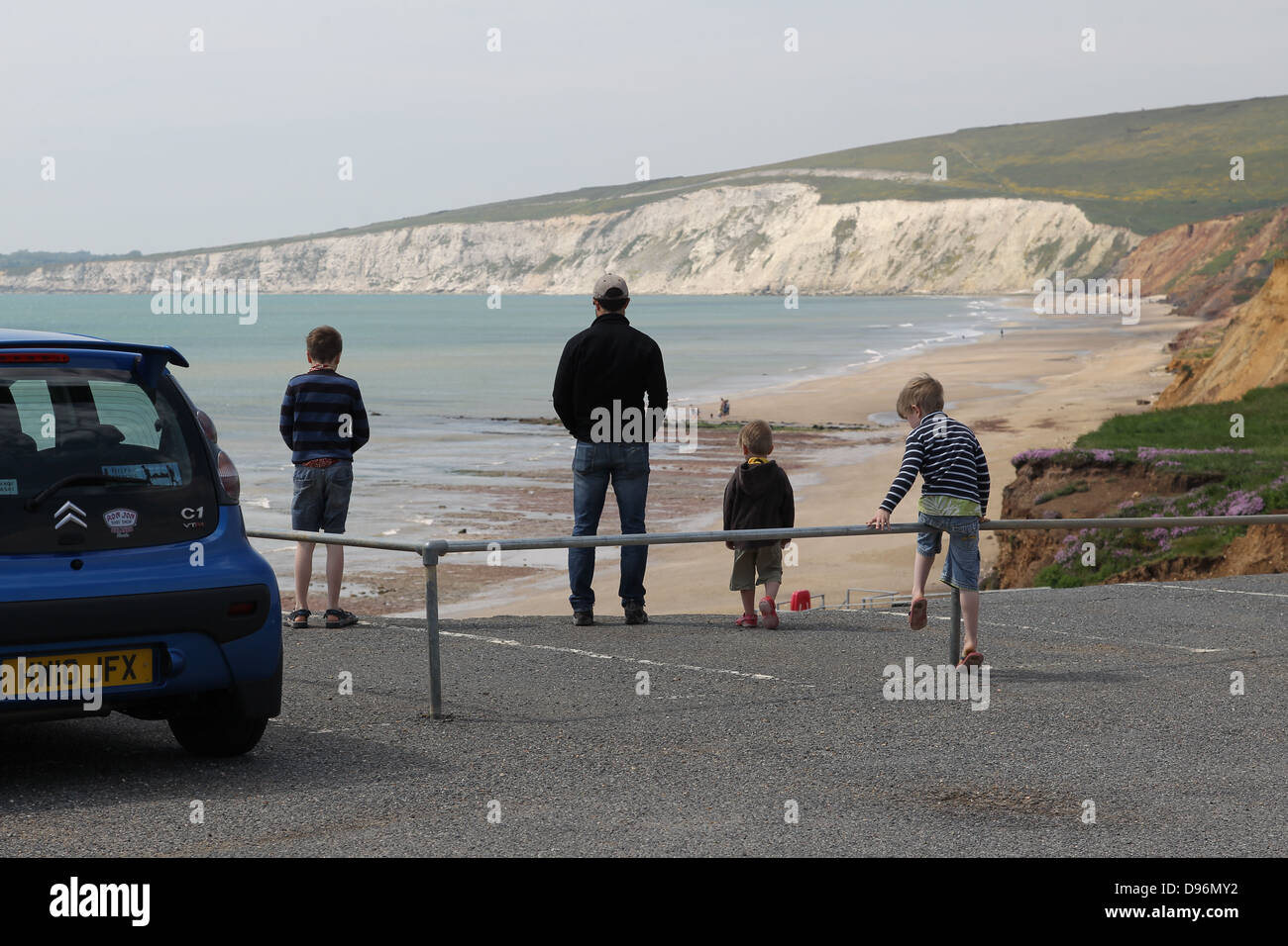 Compton Bay car park showing erosion and collapse. a family disregard the danger to get closer to the edge. Stock Photo
