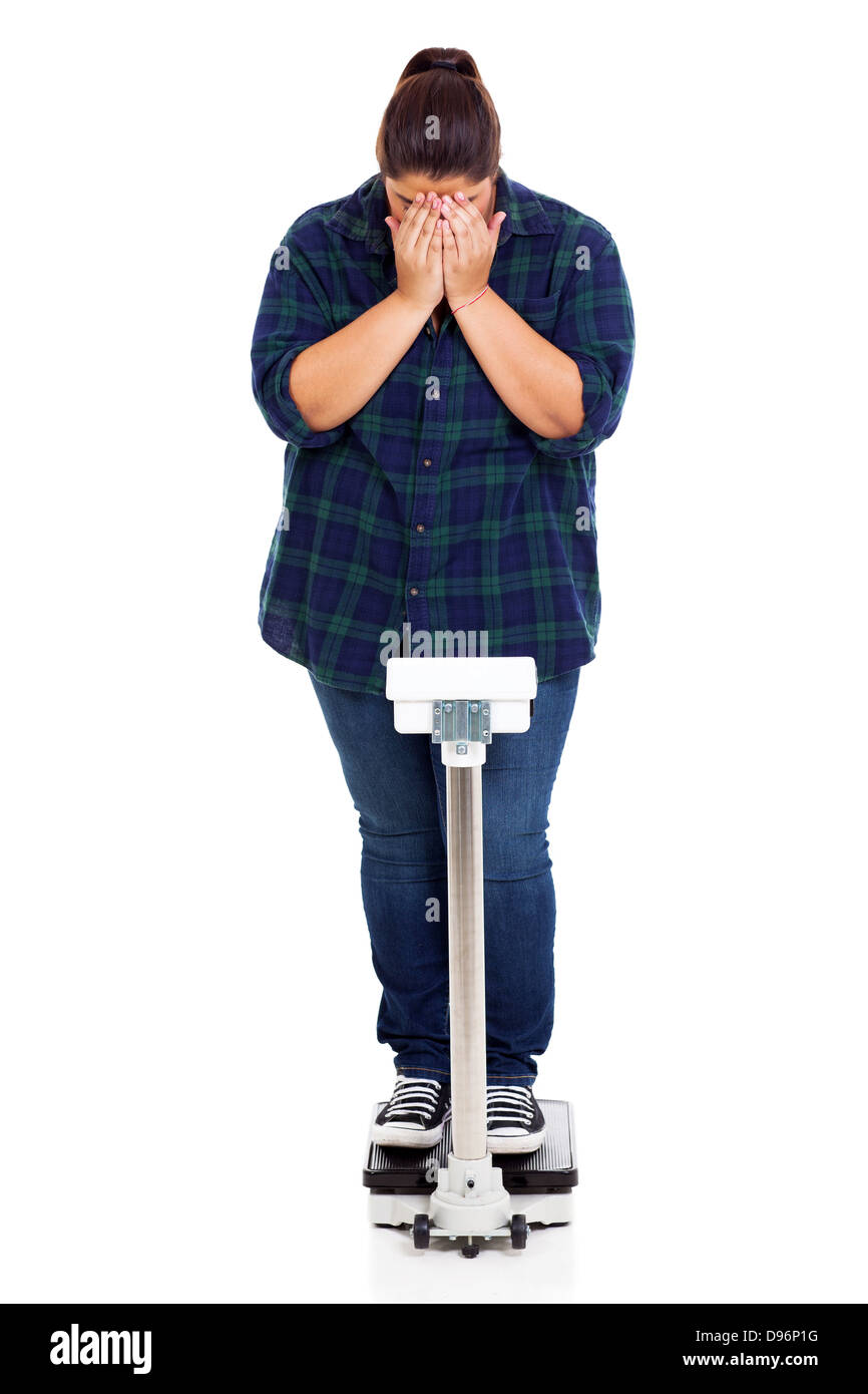 unhappy overweight girl crying when weighting on scale Stock Photo